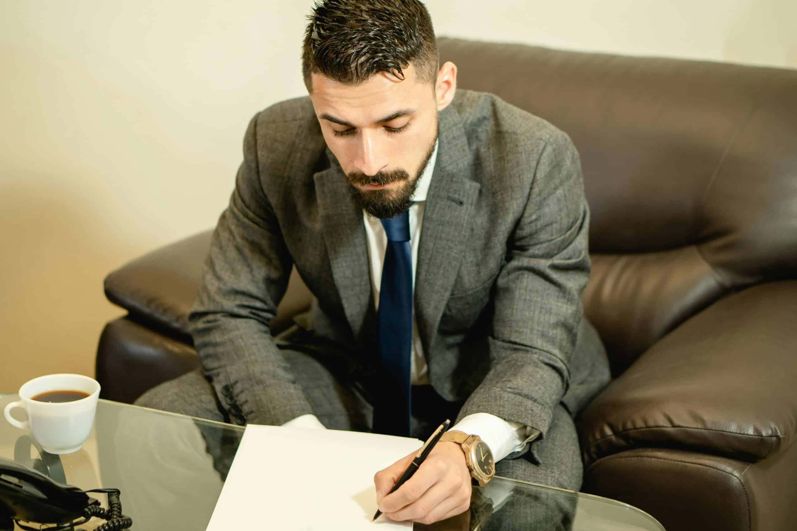 Man reading through papers at his desk